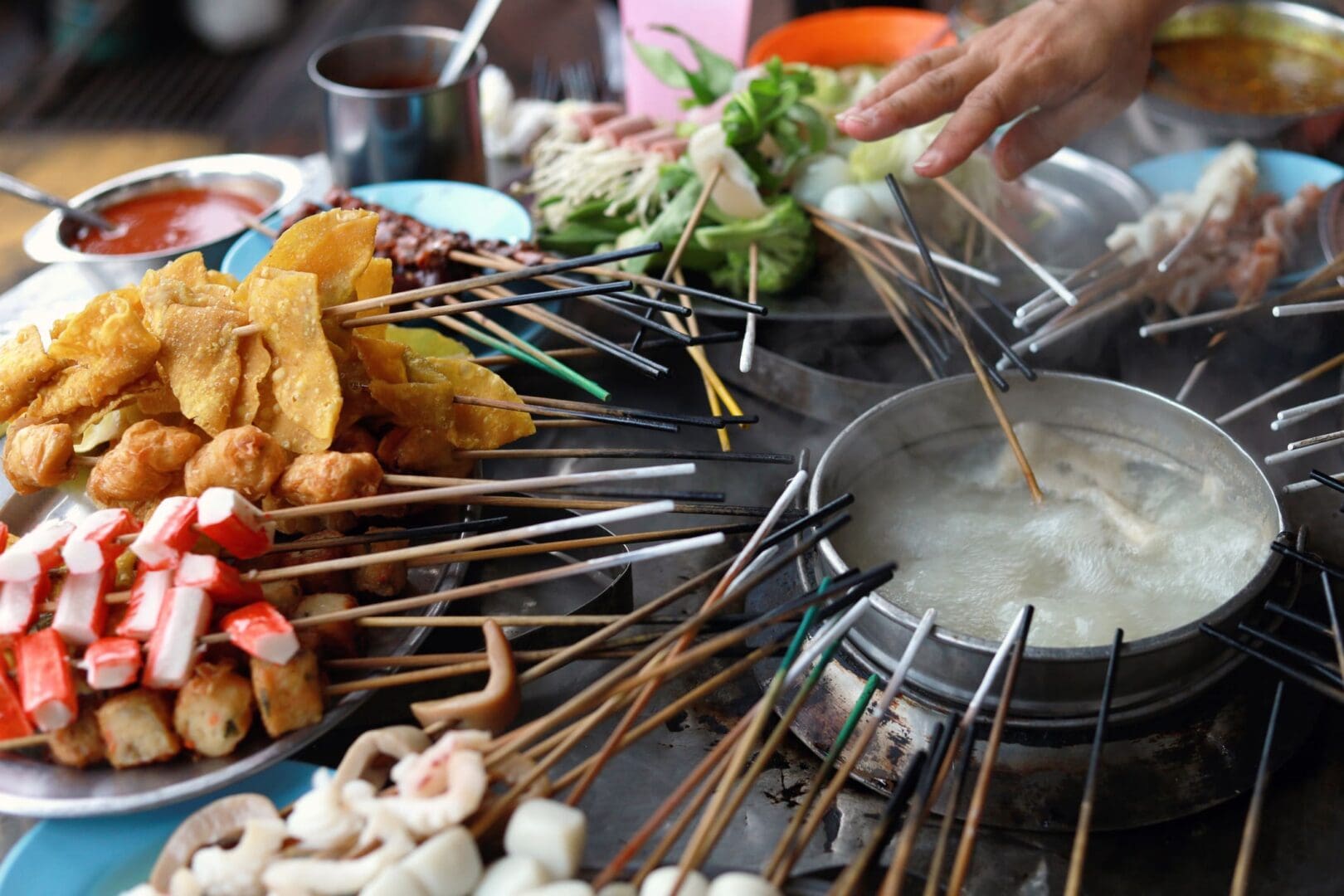 Hand cooking skewers in hot pot