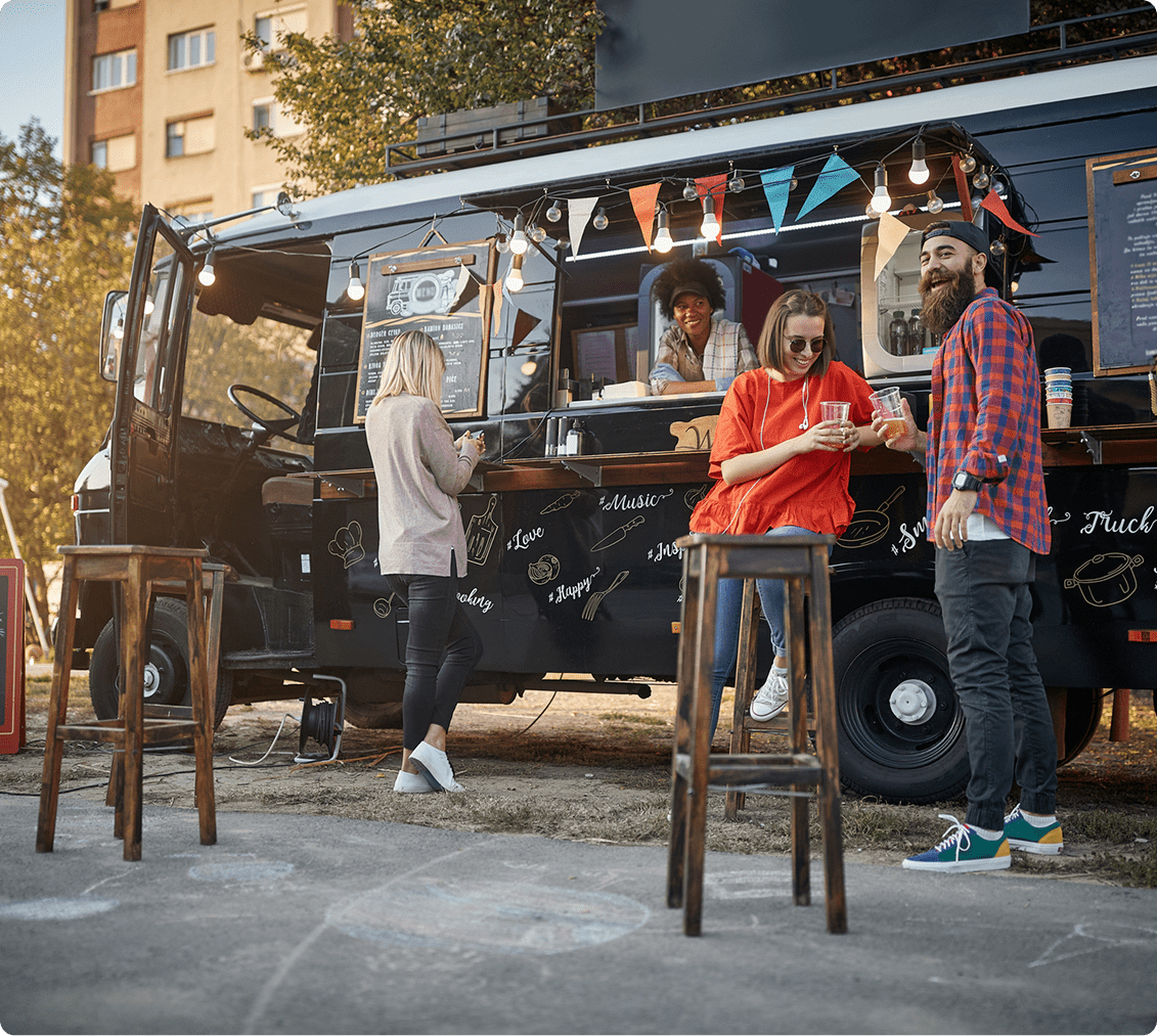Friends chatting by a black food truck